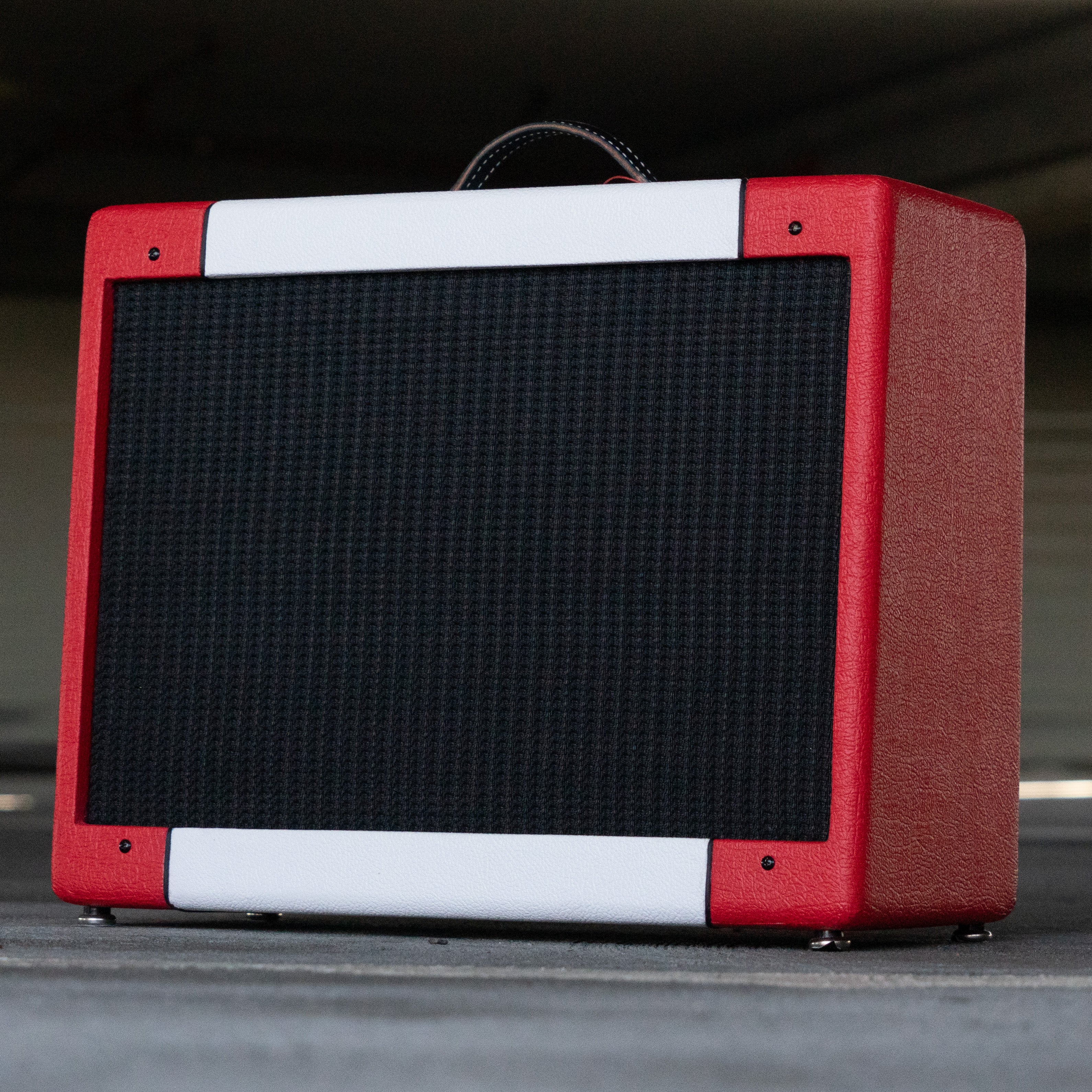 Red and white narrow panel 5E3 Deluxe amplifier with black grille cloth and leather handle.