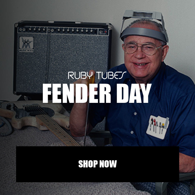 A promotional graphic for 'Fender Day' by Ruby Tubes, featuring a smiling older man wearing glasses and a headlamp in front of a Fender amplifier, with a guitar on a table in the background and a 'SHOP NOW' button at the bottom.