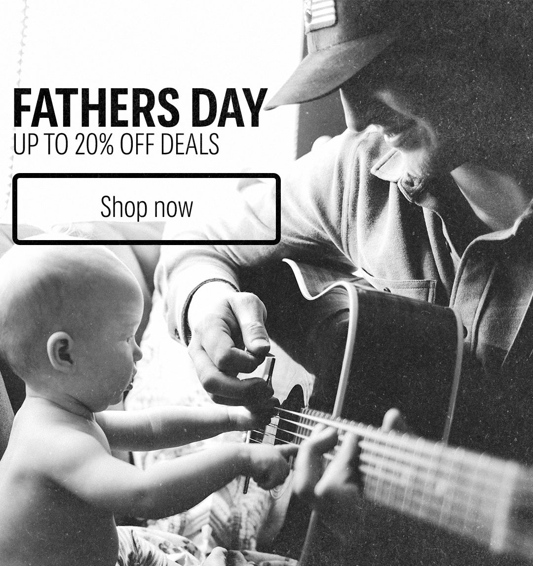 Black and white image of a father playing guitar with a baby, with Fathers Day sale text overlay.