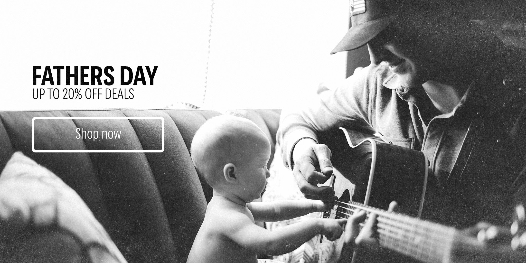 Black and white image of a man playing guitar with a baby on his lap, with Fathers Day promotion text overlay.